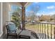 Outdoor balcony featuring a stone pillar, metal railing, seating, and a view of the neighborhood at 303 Rolling Rock Se Rd, Marietta, GA 30067