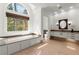 Bright bathroom featuring a soaking tub with granite surround, modern fixtures, and tiled floors at 303 Rolling Rock Se Rd, Marietta, GA 30067