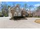 Elegant home exterior featuring a three-car garage, stone accents, and well-manicured landscaping at 303 Rolling Rock Se Rd, Marietta, GA 30067