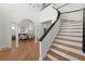 Elegant foyer with wood staircase, hardwood floors, and view to dining area with white columns at 303 Rolling Rock Se Rd, Marietta, GA 30067