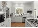 Bright kitchen with white cabinetry, stainless steel appliances, and stone countertops at 303 Rolling Rock Se Rd, Marietta, GA 30067