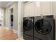 A well appointed laundry room featuring gray front load washer and dryer with storage cabinets at 303 Rolling Rock Se Rd, Marietta, GA 30067