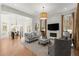 Bright living room open to dining area with fireplace, large windows, and wood floors at 303 Rolling Rock Se Rd, Marietta, GA 30067