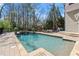 Backyard pool and patio area with a jacuzzi and outdoor dining set with red umbrellas at 303 Rolling Rock Se Rd, Marietta, GA 30067