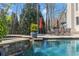 View of the large swimming pool with waterfall feature in a private backyard setting at 303 Rolling Rock Se Rd, Marietta, GA 30067