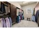 Large walk-in closet with dark wood custom shelving, ample hanging space, and a skylight at 303 Rolling Rock Se Rd, Marietta, GA 30067