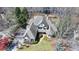 Aerial view of the home showing the architectural details and lush landscaping, nestled among mature trees at 4852 Jacobs Cove Pt, Buford, GA 30519