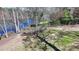 Lush backyard with mature trees, a rustic wooden fence, and partial lake view in the background at 4852 Jacobs Cove Pt, Buford, GA 30519
