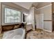 Bathroom featuring soaking tub with stone trim, stylish mirror, and vanity at 4852 Jacobs Cove Pt, Buford, GA 30519