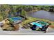Aerial view showcasing a community pool, clubhouse, tennis courts, and a lake for recreational activities at 4852 Jacobs Cove Pt, Buford, GA 30519
