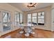 Sunlit dining area with modern table, chairs, and floor-to-ceiling windows leading to the outdoor porch at 4852 Jacobs Cove Pt, Buford, GA 30519