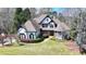 Eye-catching two-story home with black accents, multiple gables and mature trees in the front yard at 4852 Jacobs Cove Pt, Buford, GA 30519