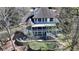 White house with a putting green and stone retaining wall nestled among mature trees and a two story deck at 4852 Jacobs Cove Pt, Buford, GA 30519