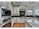 Modern kitchen featuring stainless steel appliances, granite countertops, and custom cabinetry at 4852 Jacobs Cove Pt, Buford, GA 30519