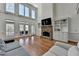 Light-filled living room with a stone fireplace, built-in bookshelves, and access to the back deck at 4852 Jacobs Cove Pt, Buford, GA 30519