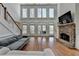 Bright living room featuring hardwood floors, stone fireplace, and large windows offering ample natural light at 4852 Jacobs Cove Pt, Buford, GA 30519