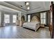 Spacious main bedroom with tray ceiling, large windows, and stylish decor at 4852 Jacobs Cove Pt, Buford, GA 30519