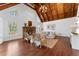 An open living room with wood ceiling, hardwood floors, stone fireplace, and a cozy seating area at 790 Denards Se Ml, Marietta, GA 30067