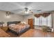 Bedroom with ceiling fan, dark furniture, and wood floors at 8698 Twin Oaks Dr, Jonesboro, GA 30236