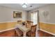 Dining room featuring hardwood floors, classic wainscoting, and a decorative light fixture at 8698 Twin Oaks Dr, Jonesboro, GA 30236