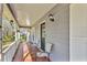 Covered front porch with seating area and decorative exterior lighting fixture at 8698 Twin Oaks Dr, Jonesboro, GA 30236