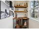 Stylish bar area with floating wood shelves, beverage coolers, and natural light from a window at 1198 Olmsted Park Rd, Decatur, GA 30033