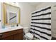 Bathroom features a vanity with wood cabinets and a shower with striped curtain at 1198 Olmsted Park Rd, Decatur, GA 30033
