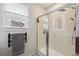 Bathroom shower with glass door, window with blind, and wall-mounted shower head at 1198 Olmsted Park Rd, Decatur, GA 30033
