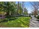 Well manicured backyard featuring a green lawn, trees and landscaping plus a brick retaining wall and sidewalks at 2820 Andrews Nw Dr, Atlanta, GA 30305