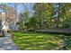 Spacious backyard with manicured lawn, mature trees, and stone patio area at 2820 Andrews Nw Dr, Atlanta, GA 30305