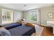 Cozy bedroom featuring twin beds, a window seat, and a view of the outdoors, complemented by hardwood floors at 2820 Andrews Nw Dr, Atlanta, GA 30305