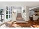 Bright foyer with large windows, staircase, terra cotta flooring and an area rug, leading into a modern kitchen at 2820 Andrews Nw Dr, Atlanta, GA 30305