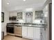 Compact kitchen featuring stainless steel appliances, white cabinets, and granite countertops at 2820 Andrews Nw Dr, Atlanta, GA 30305