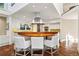 Open kitchen with bar seating, stainless steel range hood, and a combination of white cabinets and wooden countertops at 2820 Andrews Nw Dr, Atlanta, GA 30305