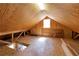 An attic with a window, exposed beams, and wooden planks at 3076 Harris Mill Ct, Duluth, GA 30096