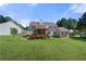Backyard featuring a spacious lawn, a deck, and mature trees offering shade and privacy at 3076 Harris Mill Ct, Duluth, GA 30096