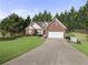 Charming brick home with an attached two-car garage and a well-manicured lawn at 3076 Harris Mill Ct, Duluth, GA 30096