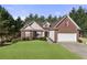 Charming two-story home features a brick facade, well-maintained lawn, attached garage, and lush green trees around the property at 3076 Harris Mill Ct, Duluth, GA 30096