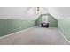 Spacious carpeted attic featuring a ceiling fan, window, and green painted walls at 407 Black Fox Dr, Locust Grove, GA 30248