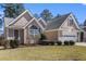A single-Gathering home with a well-maintained lawn and an attached two-car garage at 407 Black Fox Dr, Locust Grove, GA 30248