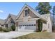 View of a two-car garage with decorative windows and a manicured front yard at 407 Black Fox Dr, Locust Grove, GA 30248