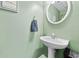 Charming half bathroom with pedestal sink, sage green walls, and classic decor at 407 Black Fox Dr, Locust Grove, GA 30248