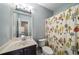 Hall bathroom with a single sink vanity, toilet, and fun patterned shower curtain at 12600 Silver Fox Court, Roswell, GA 30075