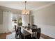 Formal dining room featuring hardwood floors, a stylish chandelier, and natural light at 12600 Silver Fox Court, Roswell, GA 30075
