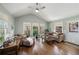 Sunlit living room with vaulted ceiling, hardwood floors, and large windows overlooking a lush backyard at 12600 Silver Fox Court, Roswell, GA 30075