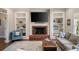 Bright living room with fireplace, built-in shelves, large windows, and neutral furnishings at 12600 Silver Fox Court, Roswell, GA 30075