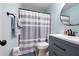 Bathroom featuring a shower with a striped shower curtain, and a blue vanity at 4057 Watkins Glen Dr, Woodstock, GA 30189