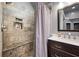 Modern bathroom with stone-tiled shower, niche, and wood vanity at 4057 Watkins Glen Dr, Woodstock, GA 30189