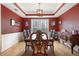 Formal dining room featuring chair rail, chandelier, and a large window with treed backyard view at 4057 Watkins Glen Dr, Woodstock, GA 30189