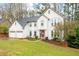 Beautiful two-story home featuring a red front door, well-maintained lawn, and a three-car garage at 4057 Watkins Glen Dr, Woodstock, GA 30189